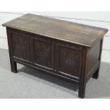 An Antique carved and panelled oak coffer, width 3' 8"