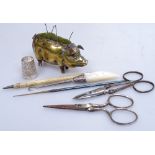 A Victorian brass pig pin cushion, length 3", sewing scissors, a mother-of-pearl button-hook etc