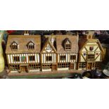 A large carved wood-framed Tudor style row of cottages, length 4'