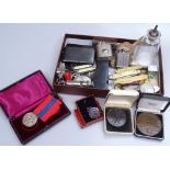 A mixed box of items, including medallions, penknives, miniature frames, pocket lighters, a medal