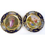 A pair of 19th century Paris porcelain plates, with hand painted romantic panels in blue and gilt