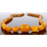 A string of graduated amber beads, largest bead length 15.7mm, necklace length 510mm, 16.4g