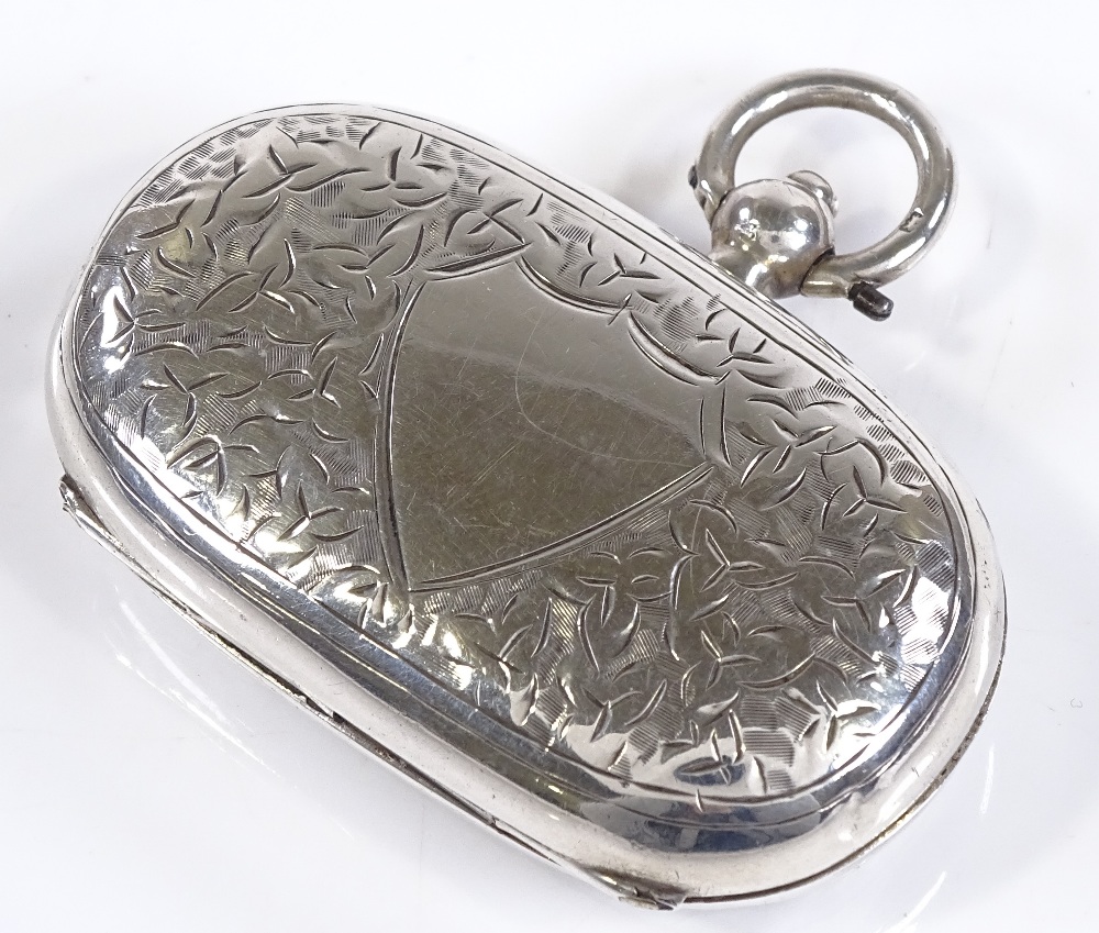 An oval silver sovereign and half sovereign case, with engraved leaf decoration, by Smith & Bartlam,