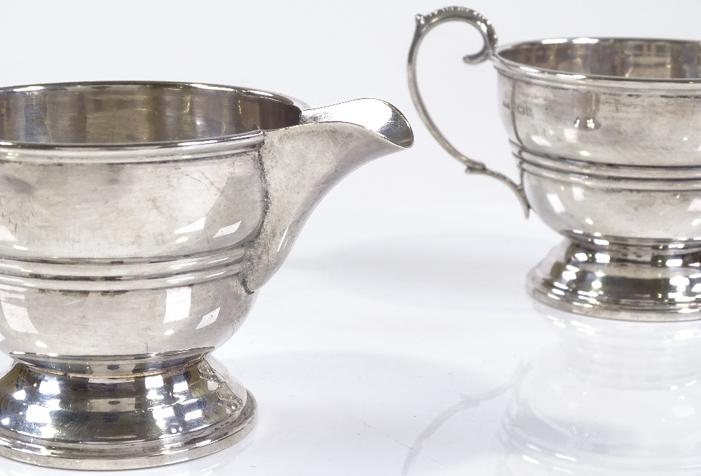 A matching silver cream jug and sugar bowl, of circular form with banded body, by Ernest W