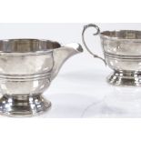 A matching silver cream jug and sugar bowl, of circular form with banded body, by Ernest W