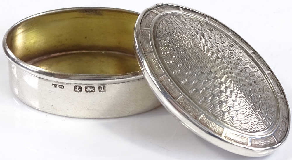 An oval silver pillbox, with engine turned lid, by Levi & Salaman, hallmarks Birmingham 1910, length - Image 2 of 3