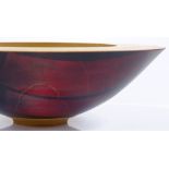 A handmade turned wood bowl, with red stained geometric underside, diameter 24.5cm