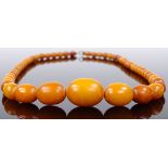 A string of graduated amber beads, largest bead length 19.3mm, necklace length 390mm, 18.2g