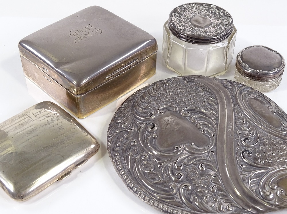 A large silver-mounted dressing table mirror, a square silver cigarette box, a curved cigarette case