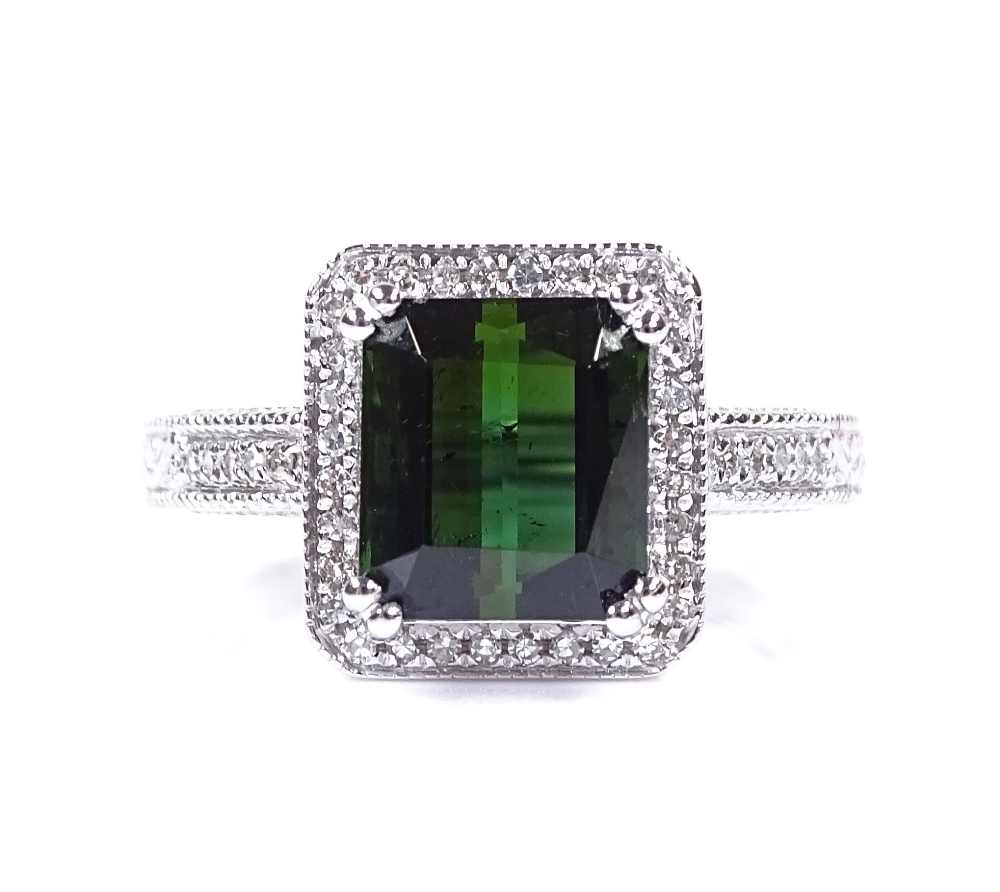 A 14ct white gold green tourmaline and diamond cluster ring, emerald-cut tourmaline approx 3.2ct,