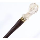 An early 20th century rosewood parasol handle, with carved ivory woman's head terminal