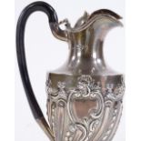 A Victorian silver hot water jug, with relief embossed half fluted body and ebony handle, by Charles