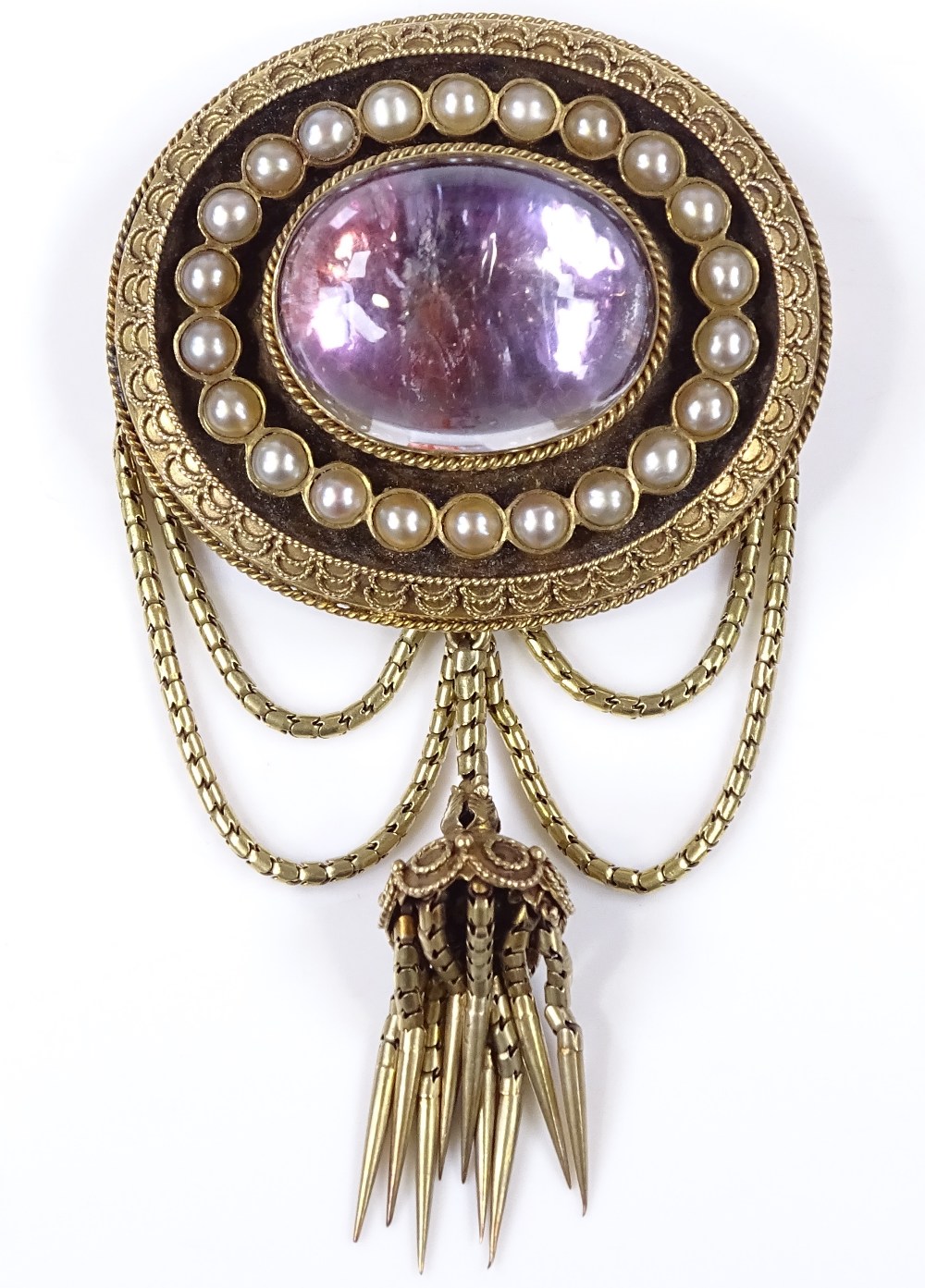 A Victorian oval memorial brooch, with foil-back domed cabochon rock crystal centre, surrounded by