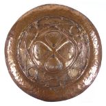 A large Newlyn style circular copper wall plaque, relief embossed entwined bramble designs, with