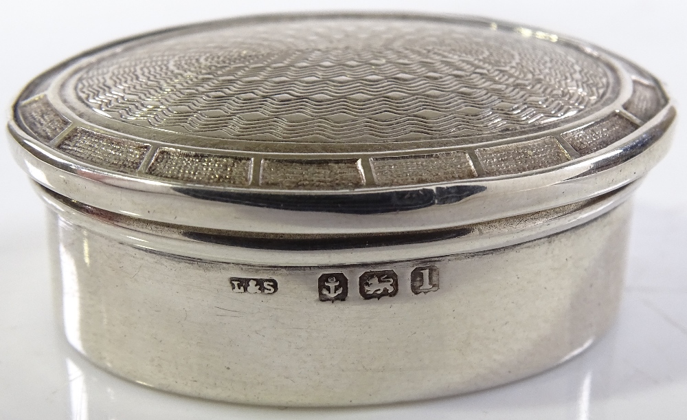 An oval silver pillbox, with engine turned lid, by Levi & Salaman, hallmarks Birmingham 1910, length - Image 3 of 3
