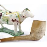 A Staffordshire Pottery cow creamer, and a Crystal Palace commemorative clay pipe, both A/F (2)