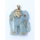 An Oriental carved jade elephant pendant, with 9ct gold mounts and red stone set eye, height