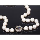 A single opera strand pearl necklace, with sapphire and diamond set clasp, unmarked white metal