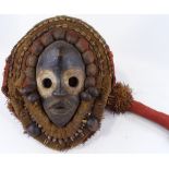 An African Dan carved wood and fabric shell-mounted stilt walker's initiation mask, height 36cm