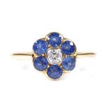 An 18ct gold sapphire and diamond flowerhead ring, central diamond approx 0.11ct, setting height 9.