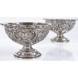 A pair of Edwardian circular silver bowls, with relief embossed floral and foliate decoration, by