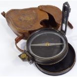 A brass military prismatic field compass, diameter 10cm, leather-cased