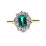 An 18ct gold emerald and diamond cluster ring, emerald approx 0.5ct, setting height 11mm, size N, 3g