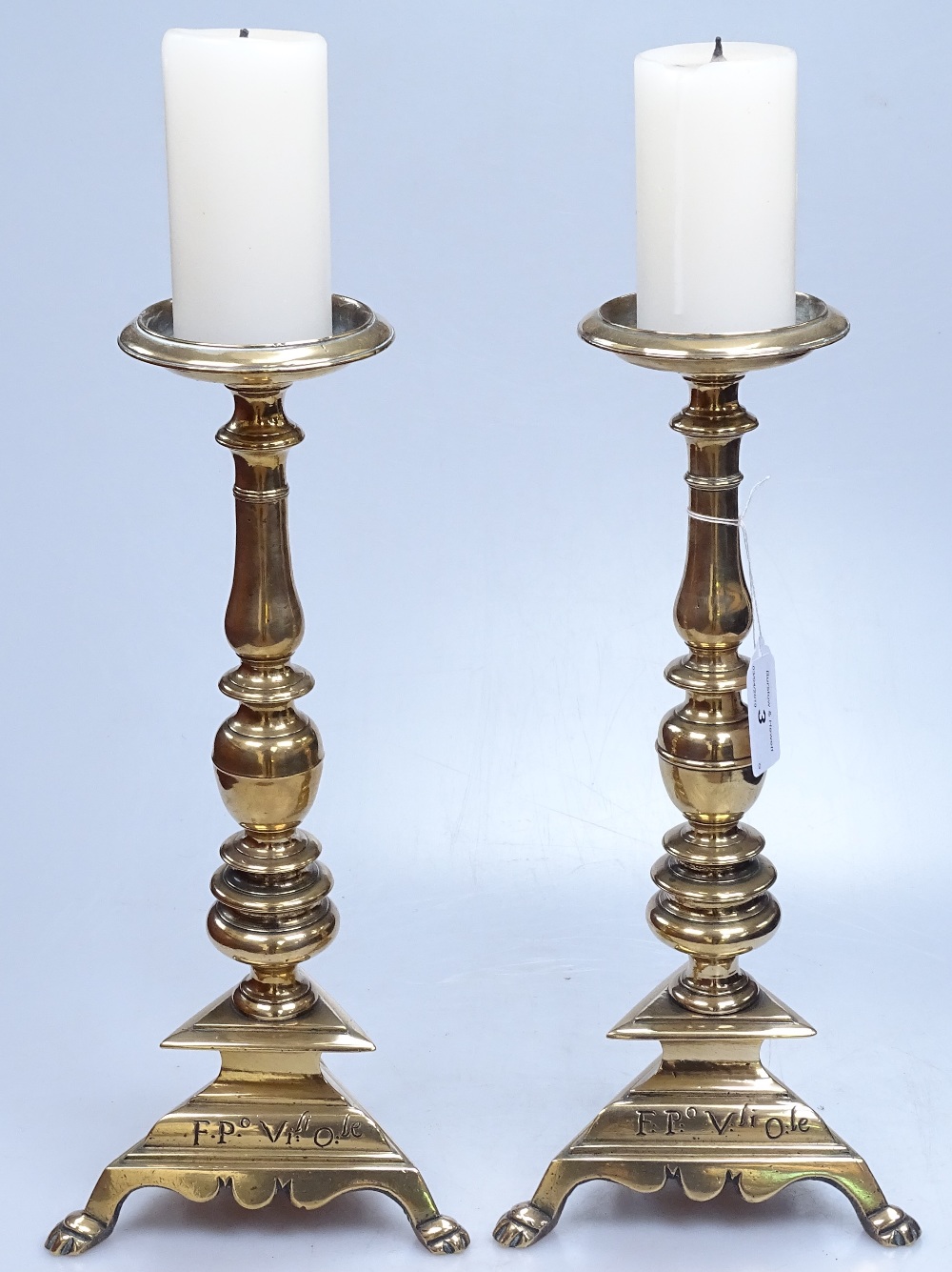 A pair of 18th century brass pricket candle stands, with inscriptions to the bases, height 12.5"