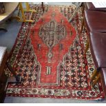 An Antique red ground Persian rug, 200cm x 122cm