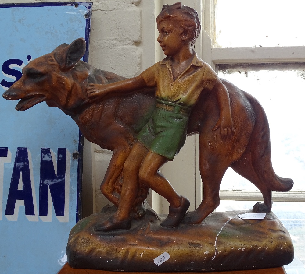 A painted plaster figure of a boy with an Alsatian, height 15.5"