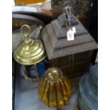 A carved wood lantern light fitting, a brass-framed lantern light, and an amber glass and wrought-