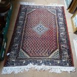 A red ground wool Persian design rug, 140cm x 103cm