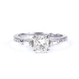 An 18ct white gold 0.65ct emerald-cut solitaire diamond ring, with tapered baguette-cut diamond