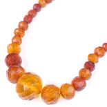 A string of graduated faceted amber beads, largest bead length 20mm, necklace length 430mm, 28.6g