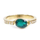 An 18ct gold solitaire emerald dress ring, with diamond set shoulders, setting height 6.2mm, size N,