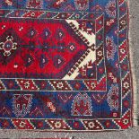 A Caucasian red and blue ground geometric pattern rug, 6'5" x 4'