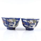 A pair of Chinese blue and red glaze porcelain tea bowls, with hand painted dragon enamel