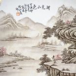 A Chinese porcelain plate with painted mountain landscape and text, diameter 22cm