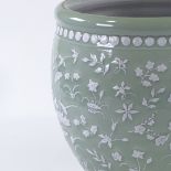 A large Chinese green glaze porcelain jardiniere, with relief embossed white glaze floral