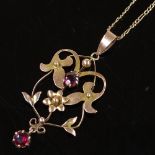 An Edwardian 9ct gold garnet open work floral pendant necklace, on 9ct flat curb link chain, pendant