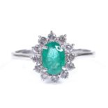 An 18ct white gold emerald and diamond cluster ring, setting height 11.2mm, size N, 2.6g