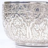 An unmarked Indian silver circular bowl, with floral embossed decoration and engraved bird base,