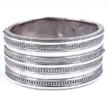 A Victorian unmarked wide silver hinged bangle, with beaded front panel, band width 31.6mm, internal