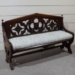 A Victorian Gothic hall seat, with carved and pierced tracery panel back and upholstered seat,