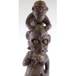 An African carved and painted wood sculpture of a monkey riding on a man's shoulders, height 80cm