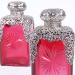 A pair of Victorian silver overlay cranberry glass spirit decanters, with pierced shoulders and