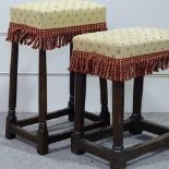 A pair of upholstered stools on oak bases