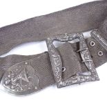 A Thai white metal mesh belt, with deity design clasp and terminal, overall length 77cm