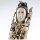A large finely carved Chinese ivory standing figure of a woman, surrounded with detailed miniature