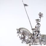 A sterling silver model of a knight on horseback holding a flag, with textured and applied